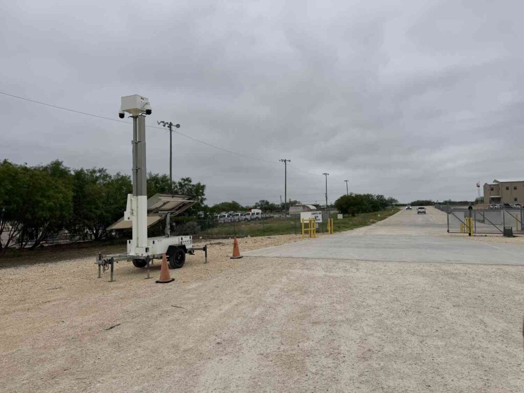 Mobile surveillance tower monitoring entrance to a secured commercial work site